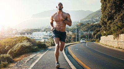 Fit muscular man with six pack abs running on the streat for a steady state cardio workout using the 4 day core workout program